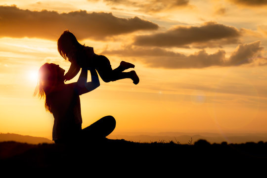 silhouette of woman on top of mountain with your daughter in sunset