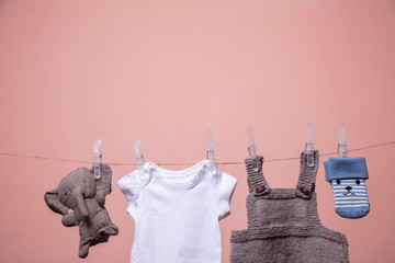 A set of cute newborn baby clothes and toys hanging on a line