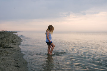 Fototapeta na wymiar Young Caucasian Girl Playing at a Beach