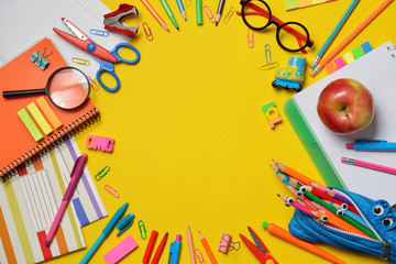 Colorful Back to School concept - office and student supplies on yellow background. Space for text.