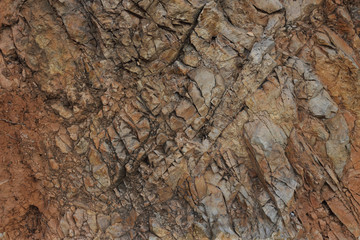 Surface of natural old cracked brown stone, texture close up.