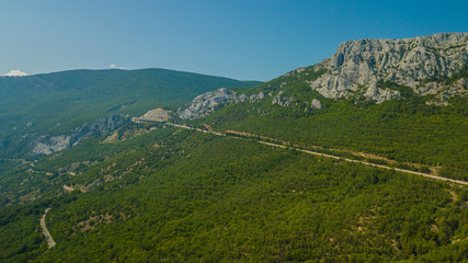 Crimean roads: aerial view of curvy mountain road in summer day