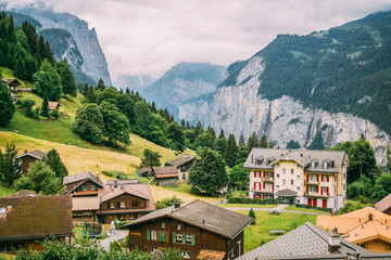 Fototapeta premium The town Wengen in the Alps mountains in Switzerland in a green summer landscape