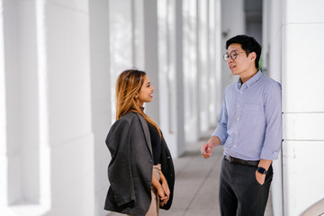 Candid shot of two diverse Asian business enthusiast, Korean man and a Malay woman having an...
