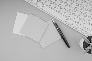 Flat lay, top view office table desk. Workspace with pen, sticky notes, decoration vase and keyboard on Black and White. Business Finance, Education and Copy Space concept