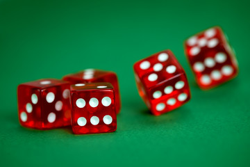 five rolling red dices on green background