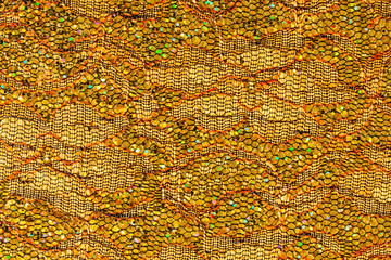 Abstract textured background of netting fabric with gold sequins