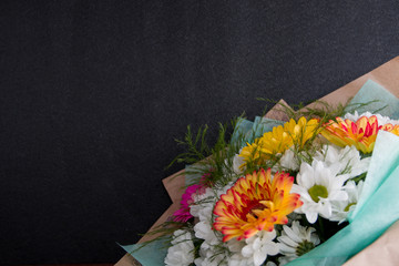 Fototapeta premium bouquet of gerberas on a black background copy space white orange pink yellow