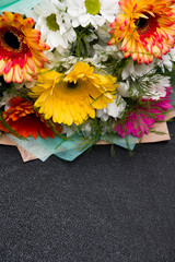 bouquet of gerberas on a black background place copy yellow green pink white orange top view