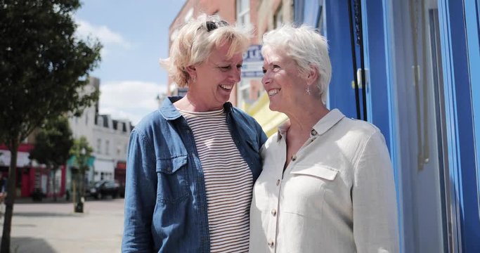 Mature lesbian couple on high street in summer