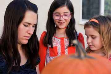 A family is decorating pumpkins during Halloween.