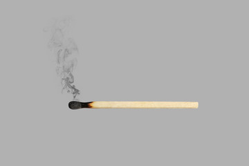 burned match with smoke isolated on gray background