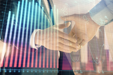 Double exposure of financial graph on cityscape background with two businessman handshake. Concept of stock market deal