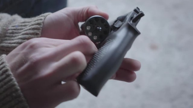Hands of young man dismantle and clean the gun close-up. The guy preparing to kill human or commit suicide