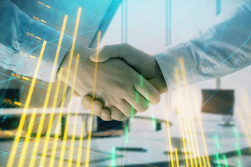 Multi exposure of financial graph on office background with two businessmen handshake. Concept of success in business