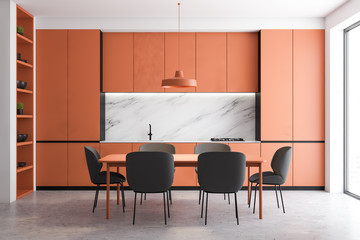 Orange and marble kitchen interior with table