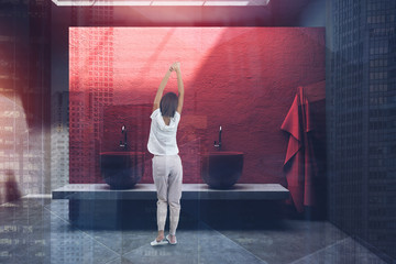 Fototapeta na wymiar Woman in red bathroom with double sink