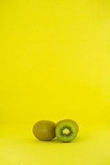 Kiwi fruit on yellow background in vertical