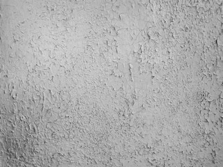 Grey paint peeling on a metallic surface background. Old grungy, weathered painted wall texture. Cracked, dirty, silver plaster falling off the construction structure