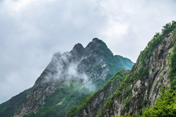 High rocky mountain peak in the clouds.