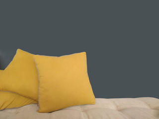 Yellow cushions on sofa on grey background