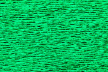 Abstract textured background of the close up detail of a sheet of green crepe paper