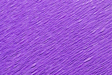 Abstract textured background of the close up detail of a sheet of purple crepe paper
