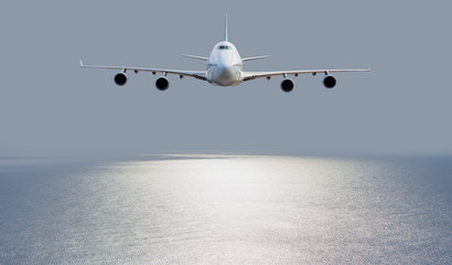 Airplane flying above tropical sea at sunset