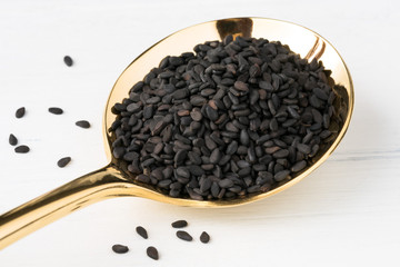 Black Sesame Seeds on a Gold Spoon