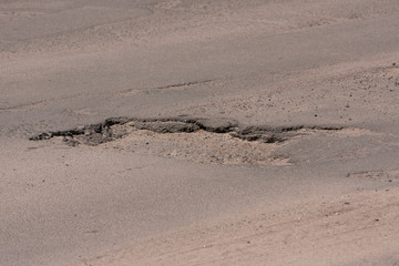 Bad roads. Hole in the asphalt, the risk of movement by car, bad asphalt, dangerous road, potholes in asphalt, pit unsafe hole road concept. Way markings in the pit.