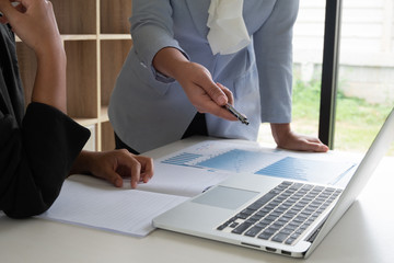 Two business leader women discussing the charts and graphs showing the results