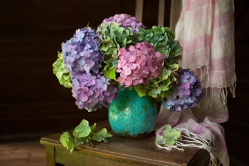 Fotobehang Boeket hortensia bloemen in een vaas op een stoel © tachinskamarina
