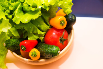 Fresh vegetables in wooden bowl. Top view. Selective focus. Weight loss for diabetic. Colorful choice of vegetables: tomatos, onion, sweet pepper,cucember and salad.