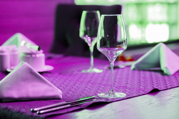wine glasses isolated on table.art neon wine glasses.Purple, colorful bright lights.Minimal Fashion Stillife. Art gallery Design. Vanilla Trendy Bright Colors. Blue Neon Mood, Surrealism.