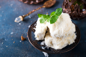 Traditional Turkish cotton candy Pismaniye in vintage plate with tea on stone background