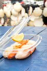 fresh raw scallops in a plastic box for take away