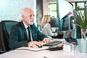 Senior business man wearing formalwear working on computer in office