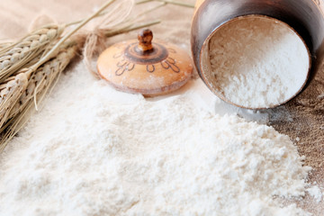 Whole wheat flour. Grain product concept, agriculture. Flour from a barrel on a table with ears of wheat.