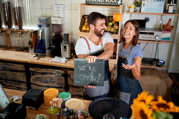 Business owner holding Open Sign. couple opening their store.