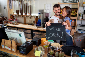 we are open - couple opening their coffee shop.