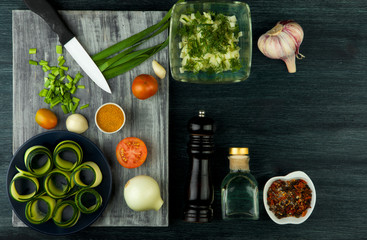 Zucchini in the background. Fried young sliced courgettes in a pan on a dark background. The view from the top. Copy space