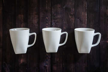 3 coffee mugs on a wooden table background - morning pick me up drink