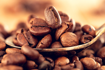 Morning with delicious coffee. Coffee seeds close-up on a teaspoon. Shallow depth of field.