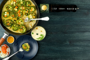 Zucchini in the background. Fried young sliced courgettes in a pan on a dark background. The view from the top. Copy space
