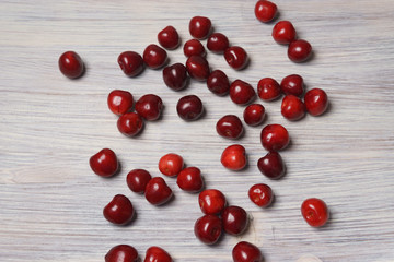 Red sweet cherry scattered on a white wooden table