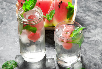 Watermelon cocktail. Watermelon cocktail with mint, slices of watermelon and ice cubes on a gray concrete surface. View from above. Copy space.