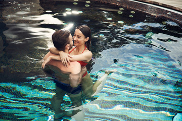 Lovely couple hugging in the swimming pool