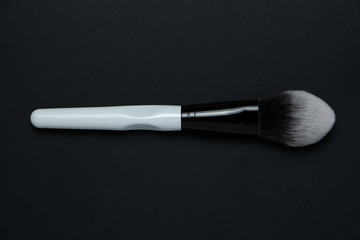white cosmetics brush on the black background