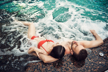 Lovely couple lieing in the swimming pool