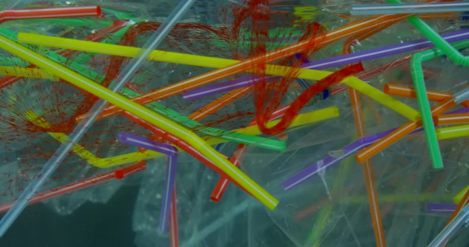 Polluting And Damaging Oceans With Plastic Waste With Plastic Colourful Straws And Bottles